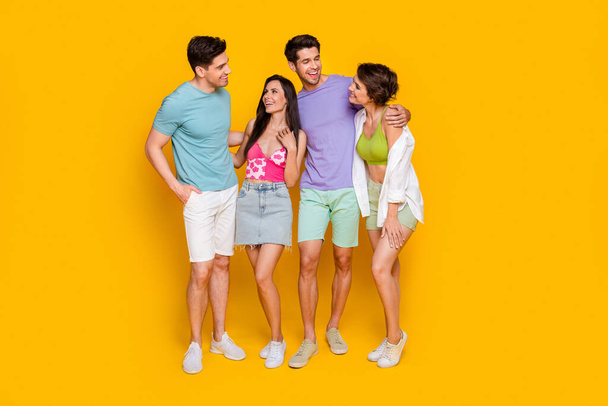 Full body photo of four people best buddies hug embrace have fun chat isolated over vivid color background. - Fotoğraf, Görsel