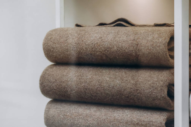 Close-up de camisolas castanhas de caxemira dobradas em uma pilha - Foto, Imagem