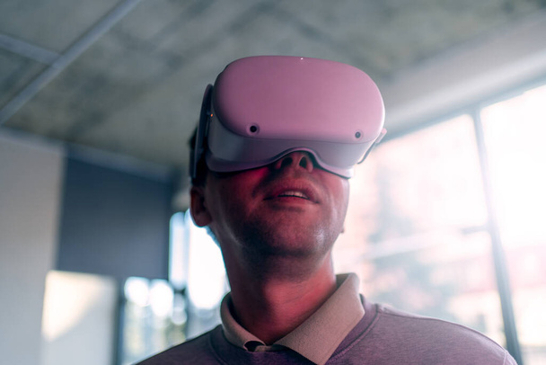 Giovane uomo profondamente impegnato con cuffie realtà virtuale. Ottiene la prima esperienza digitale VR - Foto, immagini