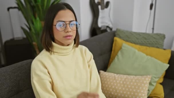 Young beautiful hispanic woman sporting simple yet stunning glasses, captures an earnest, serious look on her face. at home, her all-natural expression is a perfect blend of fashion and lifestyle. - Footage, Video