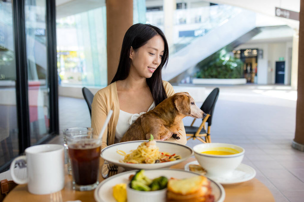 Жінка йде в ресторан зі своєю собакою в торговому центрі  - Фото, зображення
