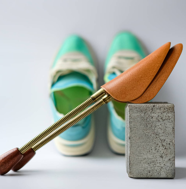 Metal Shoe Shape Holder sobre un fondo borroso de las zapatillas Aqua y Lime Color. Profundidad de campo superficial. - Foto, Imagen