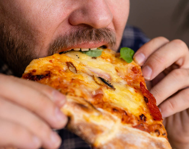 Close up photo of a man eating pizza. - Photo, Image
