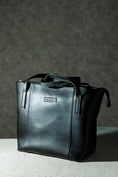 Zwarte leren tas gemaakt van echt leer op een grijze achtergrond. Lederwaren. - Foto, afbeelding