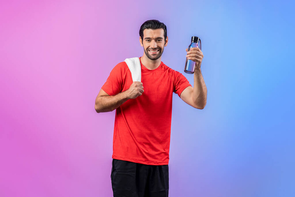 Full body length gaiety shot athletic and sporty young man with towel and drinking water in fitness exercise posture on isolated background. Healthy active and body care lifestyle. - Photo, Image