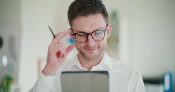 Zelfverzekerde jonge zakenman die digitale tablet gebruikt terwijl hij in de bedrijfsruimte staat - Video