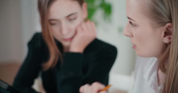 Magabiztos fiatal üzletasszony stratégiát vitat meg női kollégájával az irodában - Felvétel, videó