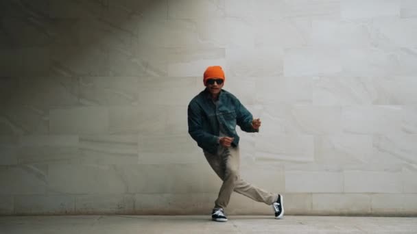 Professionelle asiatische Hipster führen Breakdance vor grauem Hintergrund auf. Streetdancer üben Hip-Hop-Schritte, während sie stylische Hip-Hop-Kleidung tragen und sich zu funkiger Musik bewegen. Outdoor-Sport 2024. Schwungvoll. - Filmmaterial, Video