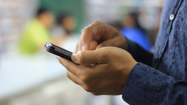 Egy ember használ a smartphone a könyvesbolt - Felvétel, videó