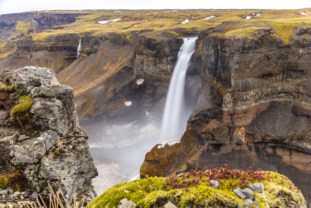 Haifoss-Wasserfall im Fossardalur-Tal in Island, Blick auf die tiefe Schlucht mit Gras und Moos bedeckt, Langzeitbelichtung. - Foto, Bild