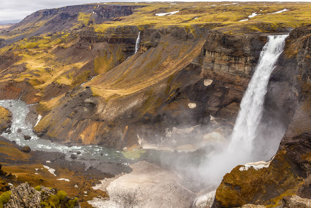 Водопад Хайфосс в долине Фоссардалур в Исландии, вид на глубокий каньон, покрытый травой и мхом. - Фото, изображение