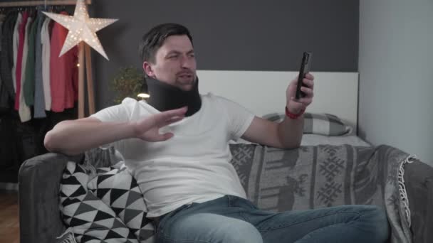 Az ember online videóhívással mutatja be a barátainak a nyakörv balesetet követően. A férfi habszivacs nyakörvvel videokonferenciát tart, és elmondja, hogyan érte trauma. A balesetet követően testi sérülésekkel küzdő fickó.  - Felvétel, videó