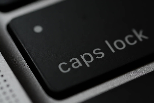 Caps Lock είναι ένα κουμπί σε ένα πληκτρολόγιο υπολογιστή που προκαλεί όλα τα γράμματα των δυαδικών σεναρίων για να δημιουργηθεί με κεφαλαία γράμματα. - Φωτογραφία, εικόνα