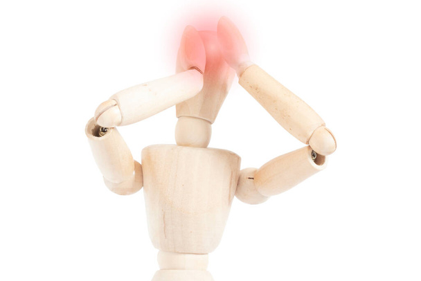 Dolor de cabeza en un maniquí de madera. Representación del dolor de migraña. Figura articulada agarra su cabeza. - Foto, Imagen