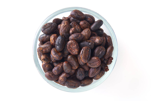 Close up Roasted cocoa beans in a glass bowl on white background - Photo, Image