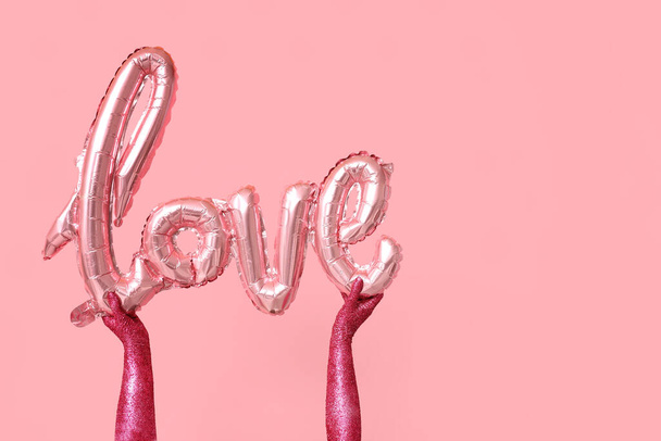 Malované ženské ruce s balónem ve tvaru slova LOVE na růžovém pozadí. Valentýnská oslava - Fotografie, Obrázek