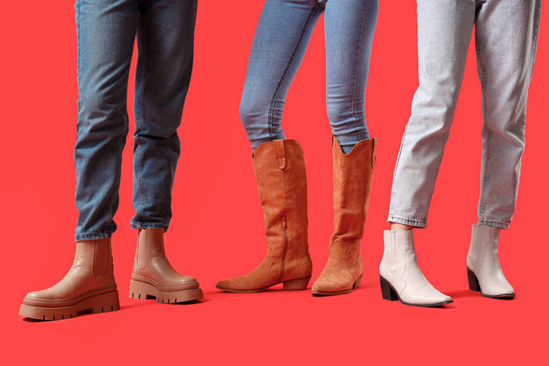 Kobiece nogi w różnych butach na czerwonym tle - Zdjęcie, obraz