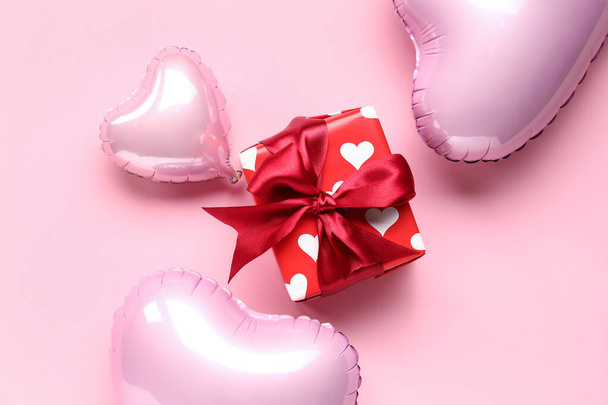 Piękne pudełko z balonami w kształcie serca na różowym tle. Święto Walentynek - Zdjęcie, obraz