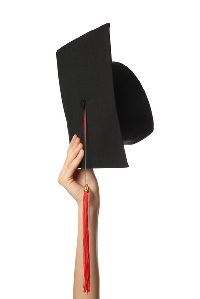 Женская рука с выпускной шляпой на белом фоне - Фото, изображение