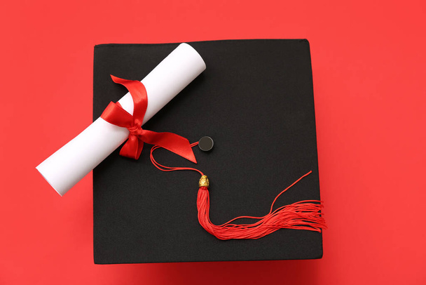 Αποφοίτηση και δίπλωμα σε κόκκινο φόντο - Φωτογραφία, εικόνα