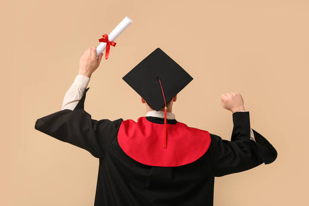 man afstuderen student met diploma op beige achtergrond - Foto, afbeelding