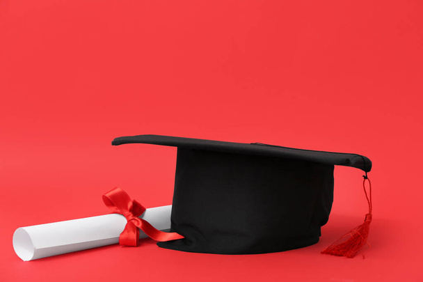 赤い背景のモーターボードと卒業証書 - 写真・画像