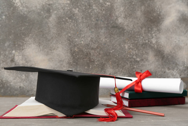 Дробова дошка з дипломом і блокнотами на сірому фоні - Фото, зображення