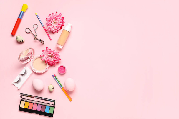 Декоративная косметика с пасхальными яйцами и цветами на розовом фоне - Фото, изображение