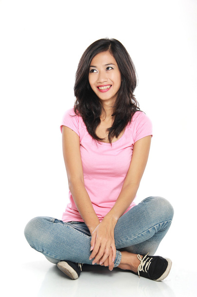 Happy young woman in casual wear sitting and thinking - Foto, imagen