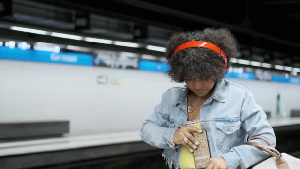 Slow motion video van een ernstige transgender persoon die de metro neemt die aankomt bij de halte - Video