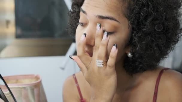 Повільне відео руху транссексуальної жінки, що поширює тінь очей пальцем під час макіяжу - Кадри, відео
