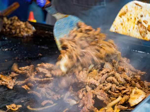 Syčící potěšení: zblízka grilované maso a cibule - Fotografie, Obrázek