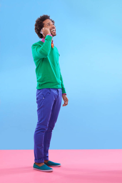 Fashion, black man and happy in studio with color block in clothes for trendy, style and outfit. Male person, stylist and fashionable for season trends with smile for funky, edgy and formal wear - Valokuva, kuva