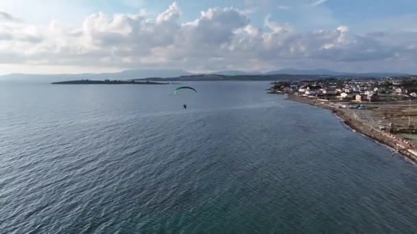 Letecké sledování paramotora letícího nad mořem s dronem. Vysoce kvalitní 4K záběry - Záběry, video