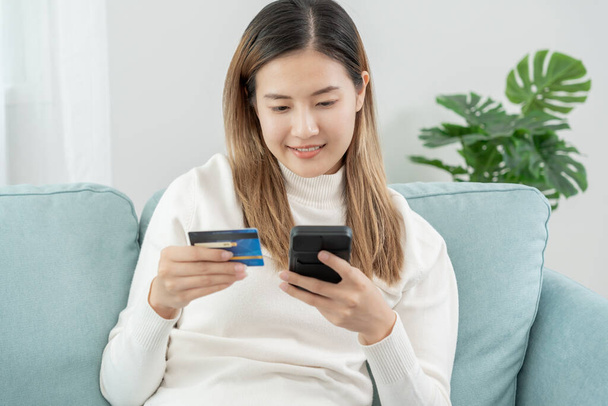Frau nutzt Smartphone für Online-Einkäufe zu Hause. Handheld-Handy mit Zahlungs-Detail-Seitenanzeige und Kreditkarte, zu Hause bleiben, Technologie, elektronischer Handel, Internet, Marktplatz - Foto, Bild
