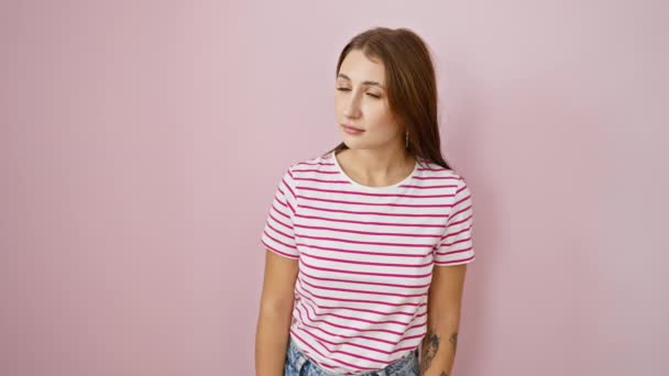 Úžasné mladé brunetky dívka v pruhy trička ukazuje dopředu, ústa dokořán překvapením, zaujat něčím neviditelným, přes izolované růžové pozadí. - Záběry, video