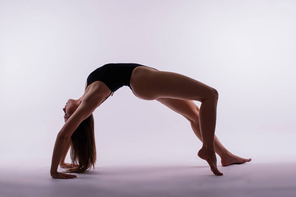 Young beautiful female yoga posing on gray studio background - Photo, Image