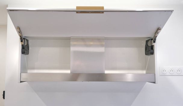 Frontansicht einer Dunstabzugshaube, die in einen Küchenschrank integriert ist - Foto, Bild