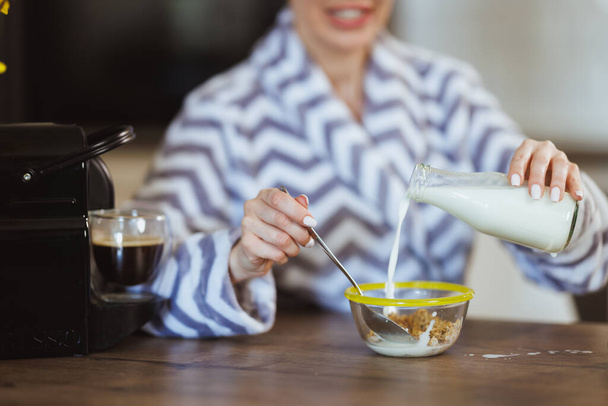 Schnappschuss einer Frau, die zu Hause ein Müsli für das Frühstück zubereitet. - Foto, Bild
