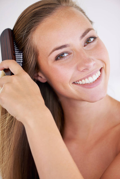 Πορτρέτο, βούρτσα ή περιποίηση μαλλιών της ευτυχισμένης γυναίκας στο μπάνιο στο σπίτι για καλλυντικά, καθαρό ή ευεξία για υγιή ανάπτυξη. Χτένισμα μαλλιών, προσώπου ή προσώπου για πρωινή ρουτίνα, ομορφιά ή κερατίνη θεραπεία. - Φωτογραφία, εικόνα