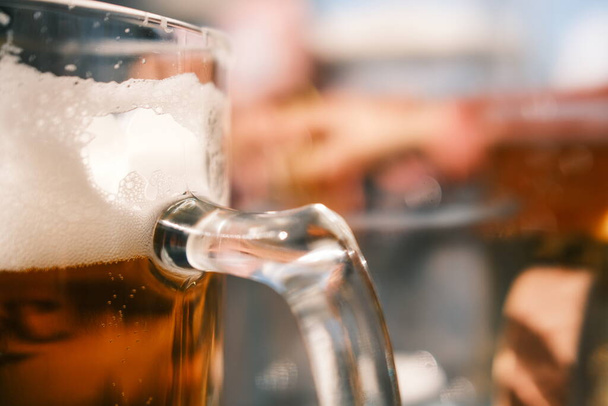 Großaufnahme von Bier im Glaskrug auf einem Holztisch in einer Kneipe. - Foto, Bild