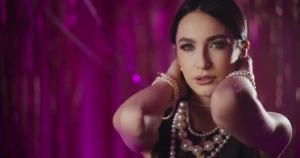 Sensual atraente jovem mulher em jóias pérola tocando rosto na frente da decoração - Filmagem, Vídeo