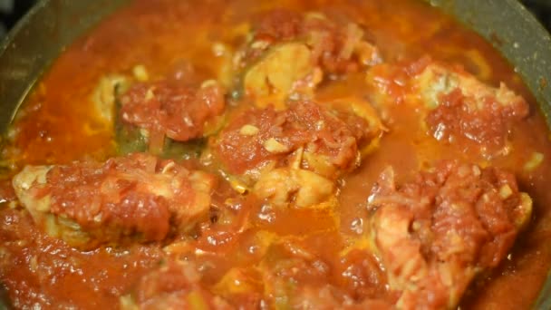 Video ukazuje, jak se rajčatová omáčka vaří ve smažené pánvi, ve které jsou dušené kousky ryb. - Záběry, video