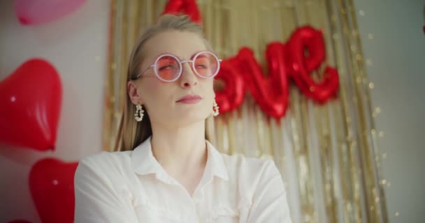 Vonzó fiatal nő szív alakú díszített szoba alatt Galentine Day - Felvétel, videó