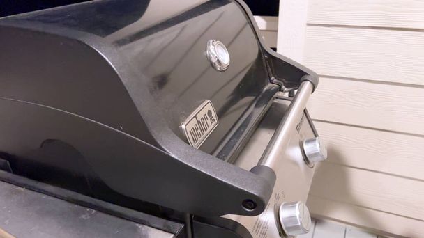 A well-prepared grilling surface awaits as the red silicone brush sweeps across the grill grates, an essential step in the preheating and cleaning process to ensure an even cooking experience. - Photo, Image