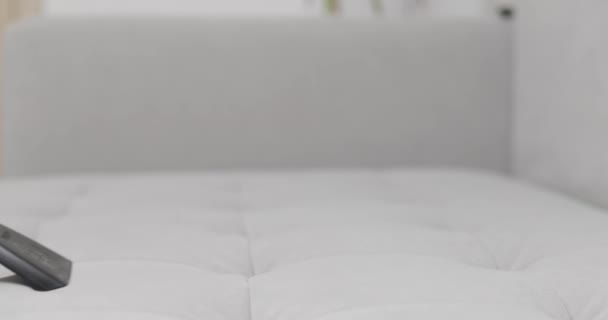 Großaufnahme eines Handstaubsaugers, der ein graues Sofa aus Stoff reinigt und sich darauf konzentriert, Staub und Allergene zu entfernen. Hochwertiges 4k Filmmaterial - Filmmaterial, Video