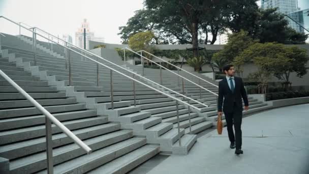 Professional business man walking near stairs while going to workplace. Skilled executive manager going to job interview at urban city. Smart investor wear suit outfit with bag. Routine. Exultant. - Footage, Video