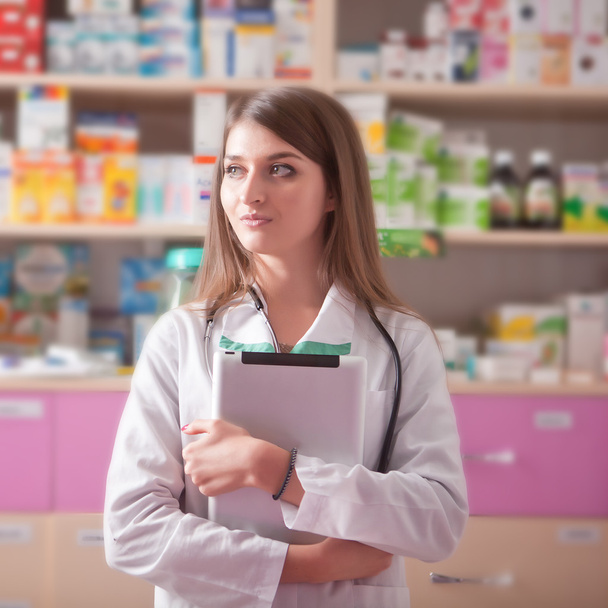 Farmacista ragazza con tablet digitale in mano in farmacia
 - Foto, immagini