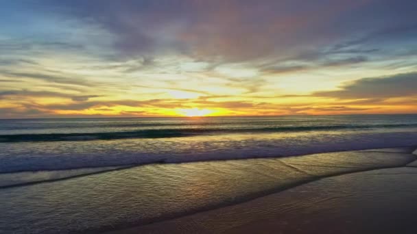 Glatte Wellen schlagen bei goldenem Sonnenuntergang am Strand auf - Filmmaterial, Video