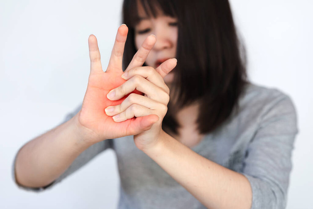 У женщины боль и онемение в руках и пальцах, вызванные использованием рук для работы много и в течение длительного времени. - Фото, изображение